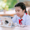 A student sits at a desk looking at a laptop computer while participating in an educational activity.